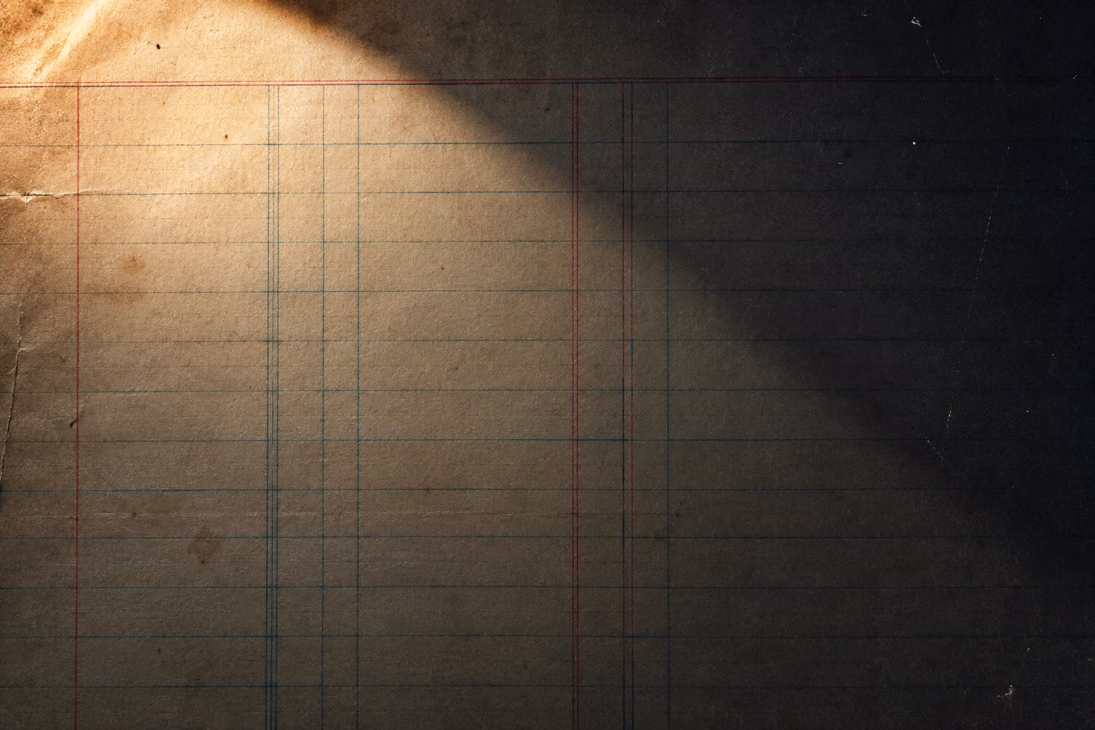 Close crop of old ledger paper with faded teal and red ruled columns, one corner in warm sunlight.